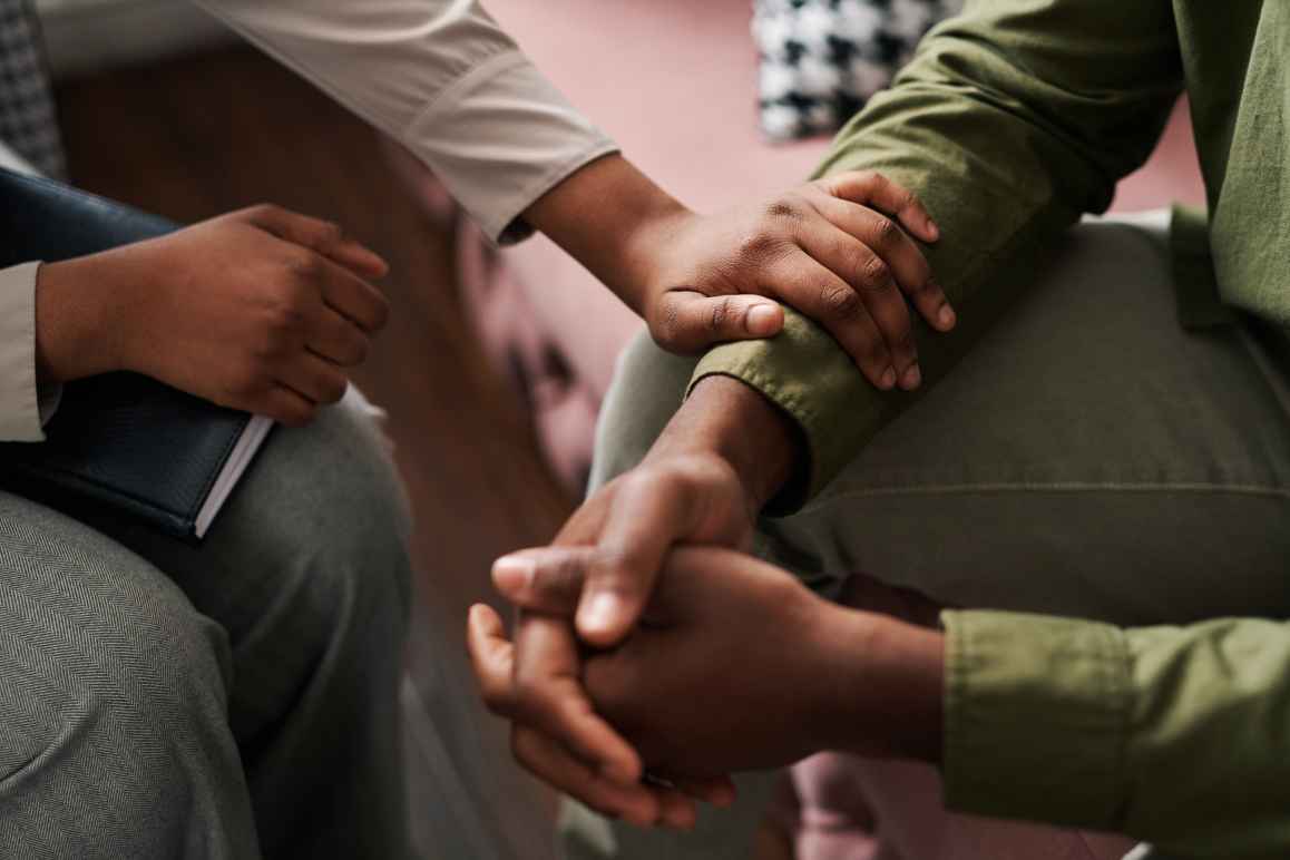 This image shows a close-up of two people engaging in a supportive, comforting interaction.