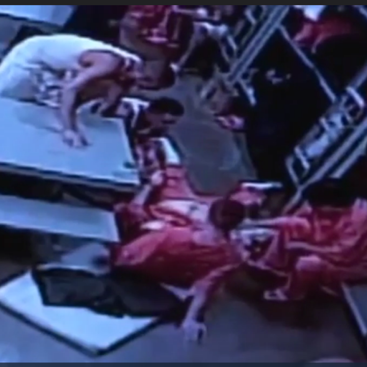 Fellow inmates tend to Douglas Edmisten as he lays on the ground in pain.
