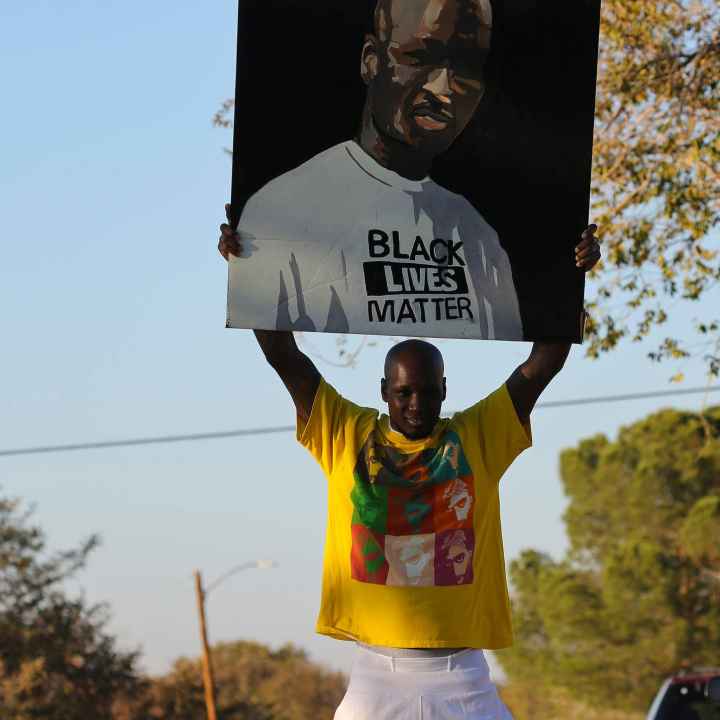 Photo of Clifton White holding a "free Clifton White" poster
